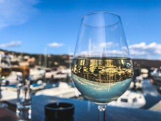 Obraz premium A glass of white wine in the sea harbor restaurant 