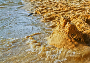 Sandcastle on the beach, the waves