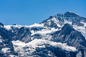 Fototapeta na wymiar Switzerland, Panoramic view on Eiger, Monch and Jungfraujoch and green Alps around Mannlichen
