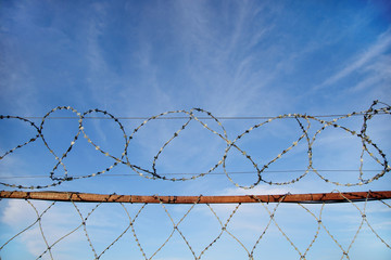 a fence with barbed wire against a beautiful sky