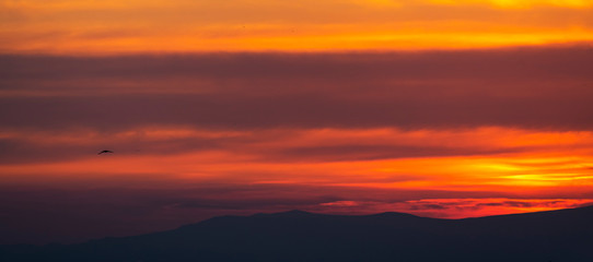 Fototapeta na wymiar Mountains silhouettes, beautiful colorful dark sunset sky with orange clouds. Nature sky background.