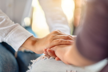 Obraz premium Women holding each other hands for comfort and sympathy