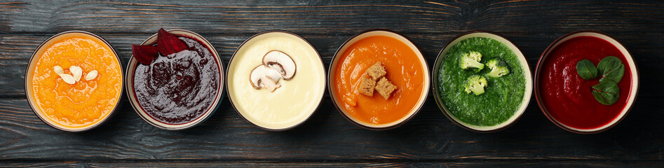 Vegetable soups on wooden background, top view