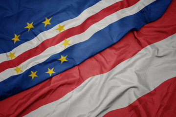 waving colorful flag of austria and national flag of cape verde.