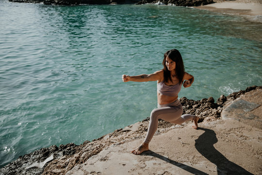 Frau die draußen am Meer auf Mallorca Yoga praktiziert 