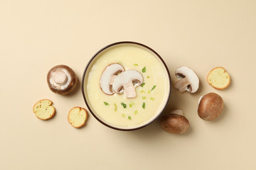 Mushroom cream soup on beige background, top view