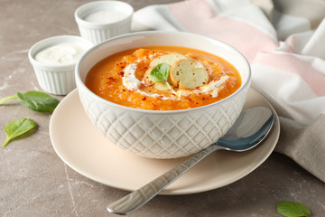 Pumpkin cream soup on grey background, close up