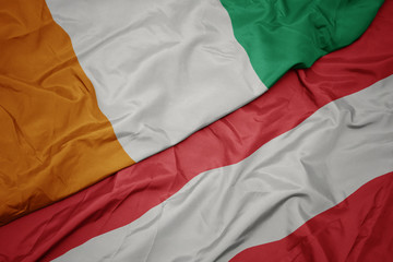 waving colorful flag of austria and national flag of cote divoire.