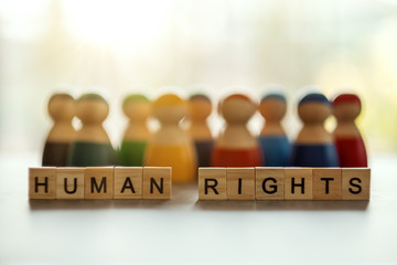 HUMAN RIGHTS word on wooden blocks with a group of people in the background