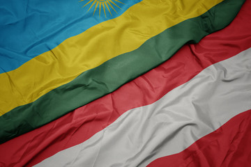 waving colorful flag of austria and national flag of rwanda.