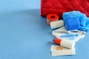 Medical case with first aid kit closeup on the blue background, flat lay.