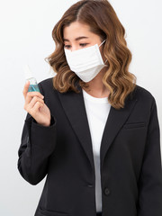 Woman wearing mask and holding alcohol spray.