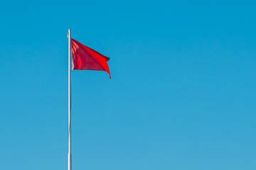 A red high-hazard beach warning flag in the sky