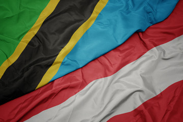 waving colorful flag of austria and national flag of tanzania.