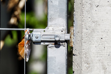 Silver door bolt on a wooden door . close up