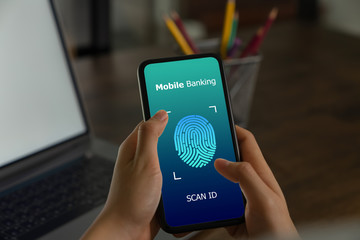 Hands holding smartphone and show the fingerprint scanner screen to access online banking.