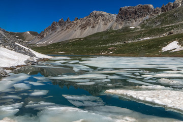 Paysage de la Haute Ubaye au printemps avec un lac en cours de dégel ; vallon de l' Orrenaye ,...