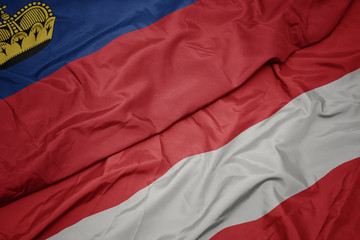waving colorful flag of austria and national flag of liechtenstein.