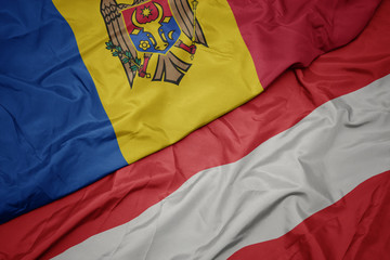 waving colorful flag of austria and national flag of moldova.