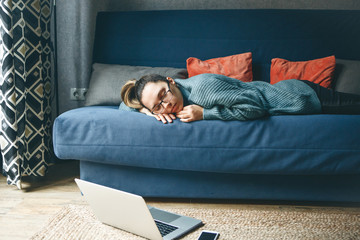 The girl is sleeping on the couch. She is tired and resting.