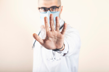 doctor shows his hand to stop the virus