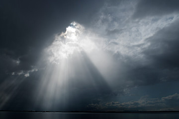 Ray Of Light Piercing The Clouds In The Sky / Storm Clearing Over The Water