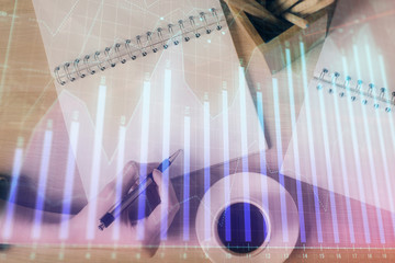 Multi exposure of woman's hands making notes with forex graph hologram. Concept of technical...