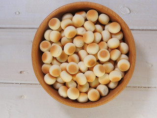 Top view of little ball cookies on wooden bowl on wooden background. Designed mouthpieces for children, which is melted into the mouth to make it easier for children to digest.