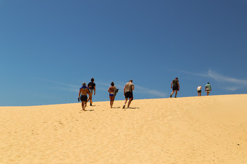 Group of friends walking up a sand dune
