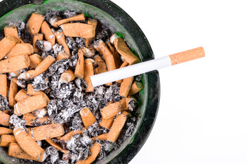 Many cigarette butts in the glass ashtray
