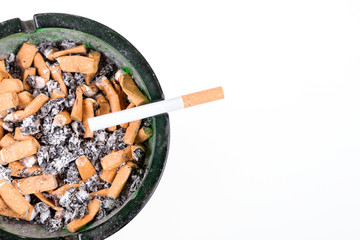 Many cigarette butts in the glass ashtray