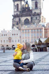 In profile, a mother and daughter in empty old town square in Prague. Czech Republic