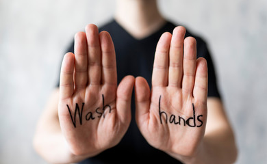 Text - wash hands, written on men's hands. Protection from the Covid-19 virus. The concept of coronavirus and pandemic