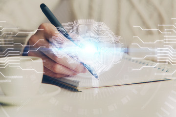 Multi exposure of writing hand on background with brain hologram. Concept of learning.