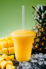 Healthy mango crush cocktail with a straw ice and pineapple