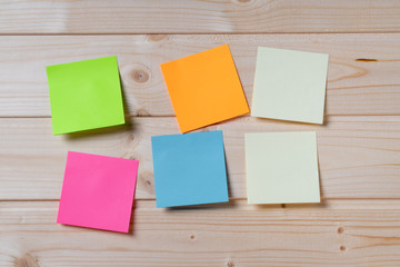 Group of colorful sticky notes on a wooden wall - Copy space