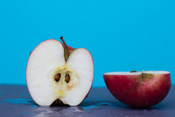 Wet sliced apple on a blue background