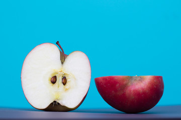 Half a sliced red apple on a blue background