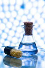 Test tubes and medicine pills on blue laboratory background