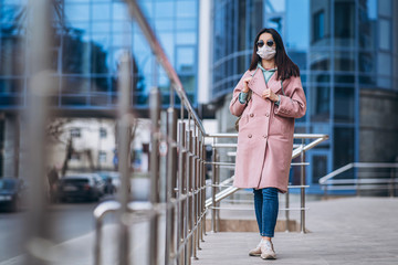 Female in medical mask outdoors in the empty city. Health protection and prevention of virus outbreak, coronavirus, COVID-19, epidemic, pandemic, infectious diseases, quarantine concept.