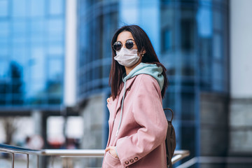 Female in medical mask outdoors in the empty city. Health protection and prevention of virus outbreak, coronavirus, COVID-19, epidemic, pandemic, infectious diseases, quarantine concept.