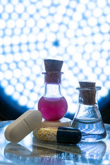 Test tubes and medicine pills on blue laboratory background