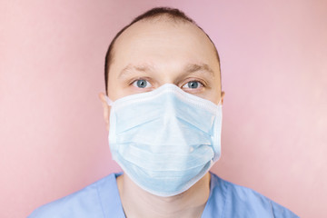 The doctor's face in surgical mask. Portrait of doctor in surgical mask.