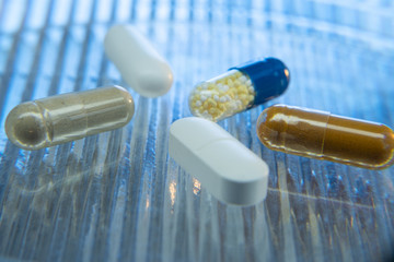 Color medicine pills on blue laboratory table