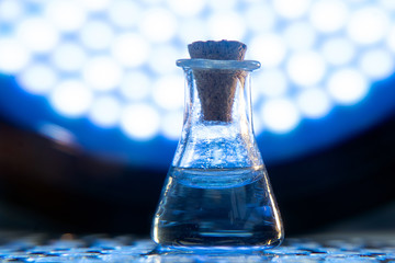 Test tube with color solution on blue laboratory background