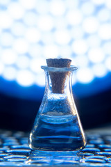 Test tube with color solution on blue laboratory background
