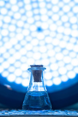 Test tube with color solution on blue laboratory background