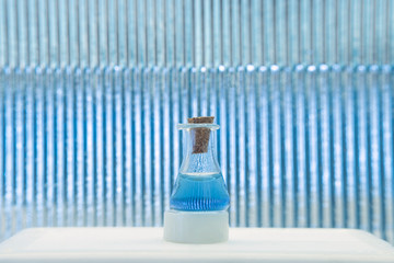 Test tube with color solution on blue laboratory background