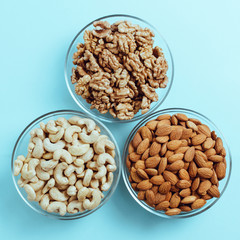 nuts in glass plates on a blue background