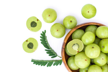 Indian gooseberry in wooden bowl isolated on white background. Top view.